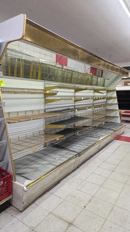 24'L of Hussmann lighted wall shelving. Features 92"H uprights, 31"D base deck, adjustable wire cantilever shelves, angled mirror canopy, and integrat