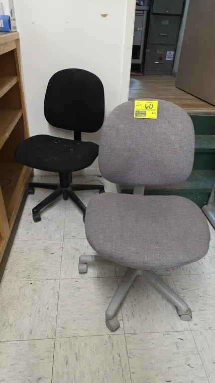 Office task chairs. Features armless design with fabric upholstered seats and backs in gray and black. Mounted on 5-star bases with casters.
