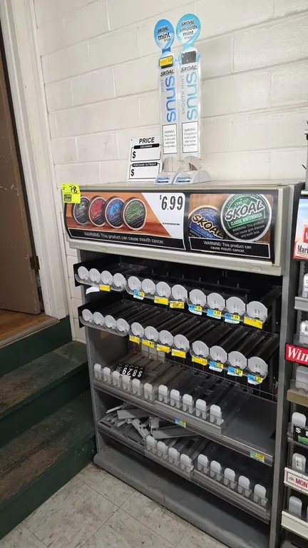 Metal tobacco display fixture. Features Skoal and Copenhagen graphic header, multi-tier shelving with spring-loaded can pushers, and (2) Skoal snus po