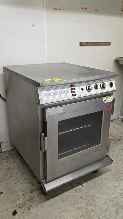 Alto-Shaam CHS-76 portable stainless steel cook, hold, and smoke cabinet. Features analog temperature and timer controls, glass window door, and inter