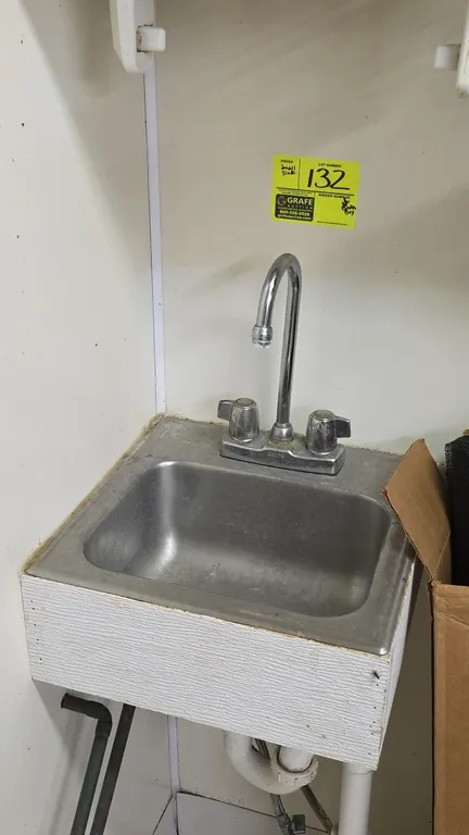 Stainless steel hand sink. Features a single compartment and a Delta deck-mount gooseneck faucet with dual knob handles. 13" x 13". Mounted in a paint