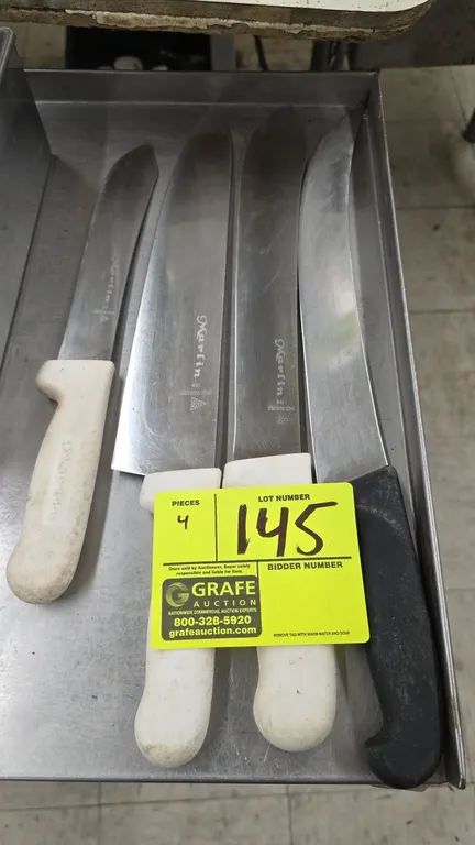 Assorted commercial butcher knives. Includes Marlin 440 stainless steel knives with white plastic handles and a Victorinox curved cimeter knife with a