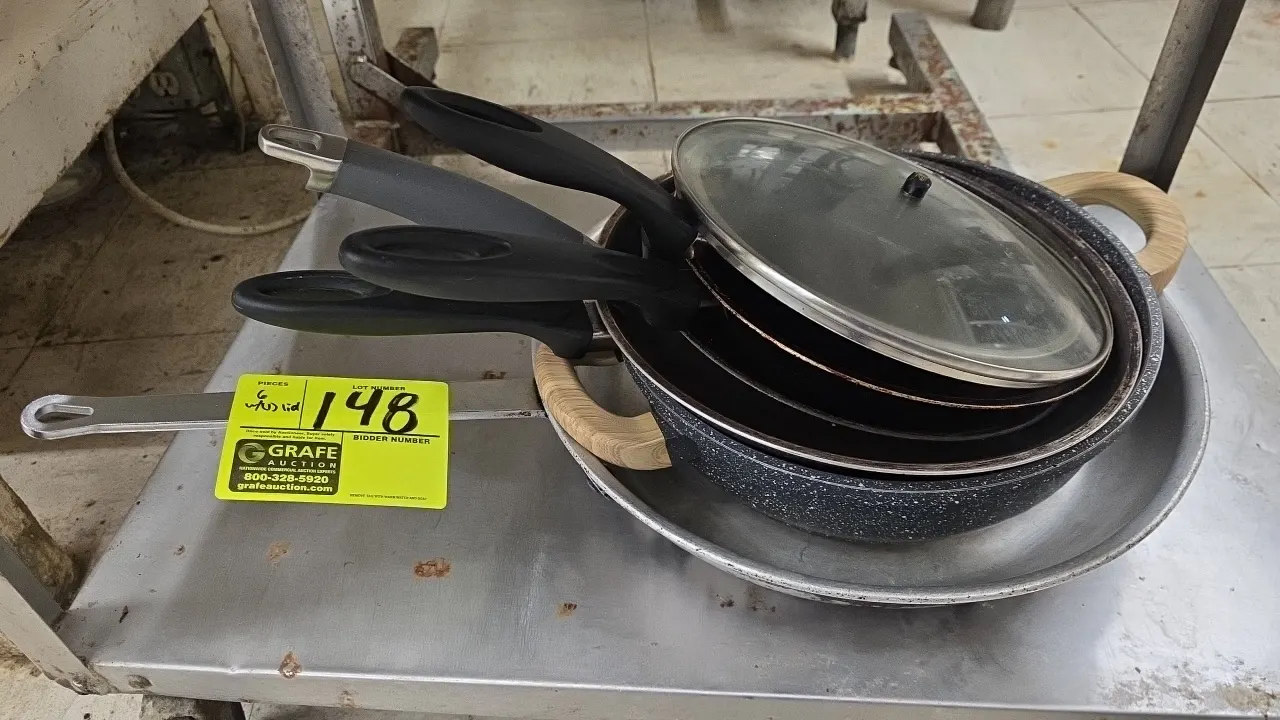 Assorted cookware skillets and pot. Includes an aluminum fry pan, speckled dual-handle pot, non-stick skillets with composite handles, and (1) glass l