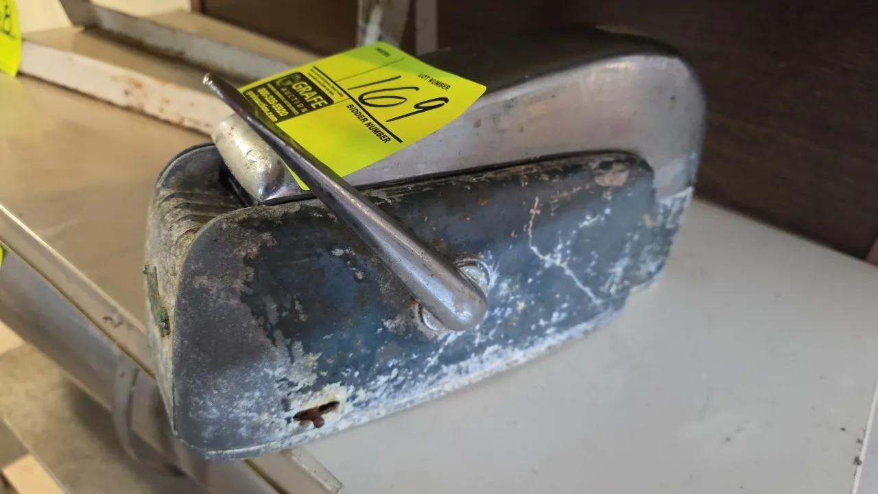 Nashua manual tape dispenser. Features cast metal housing, side lever-action feed mechanism, and integrated moistening roller assembly. Benchtop desig
