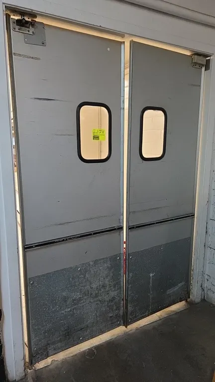 Eliason LWP Easy Swing aluminum swinging doors. Features clear vision windows, lower kick plates, and top pivot mounting hardware. Dimensions: 29.25"W