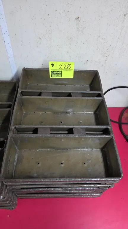 Metal strapped multi-loaf pans. Features 3-compartment bread loaf design with perforated bottoms. Measures 12.5" x 17.5".