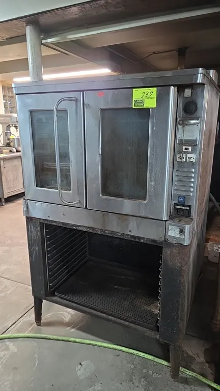 Blodgett EF 111 electric convection oven. Features dual glass doors, (3) interior wire racks, and an open base with pan storage slides. Mounted on leg