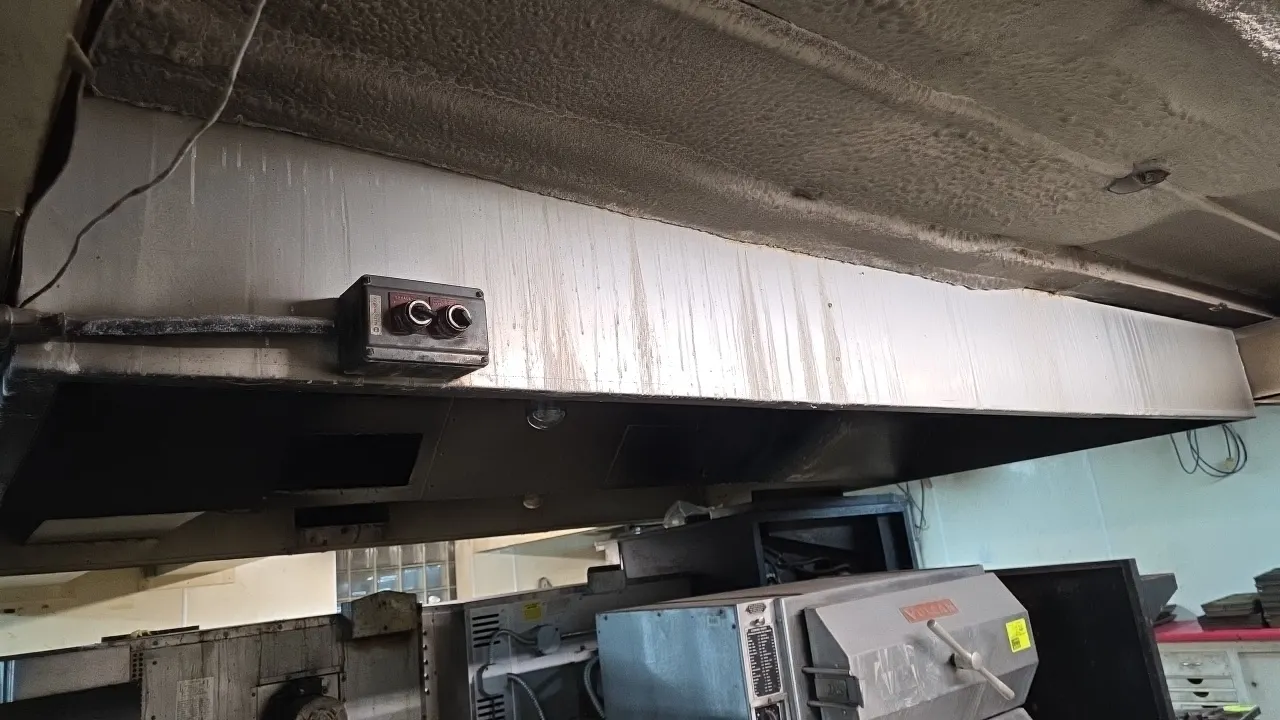 Commercial metal exhaust hood. Features integrated interior lighting and an exterior-mounted control switch box. Dimensions: 11' x 9' x 1'. Note: Equi