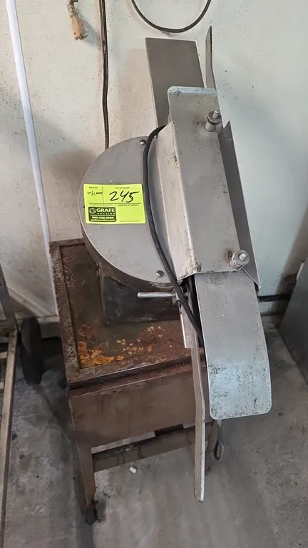 Moline bun slicer. Features stainless steel bun feed chute and adjustable guide assembly. Electrical: 115V, 60 Hz, 1-Phase. Mounted on a metal mobile