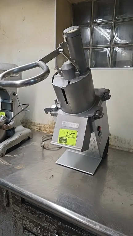 Hobart FP350 commercial food processor. Features continuous feed hopper with pusher assembly and front discharge chute. S/N: 76-1024877. Electrical: 1