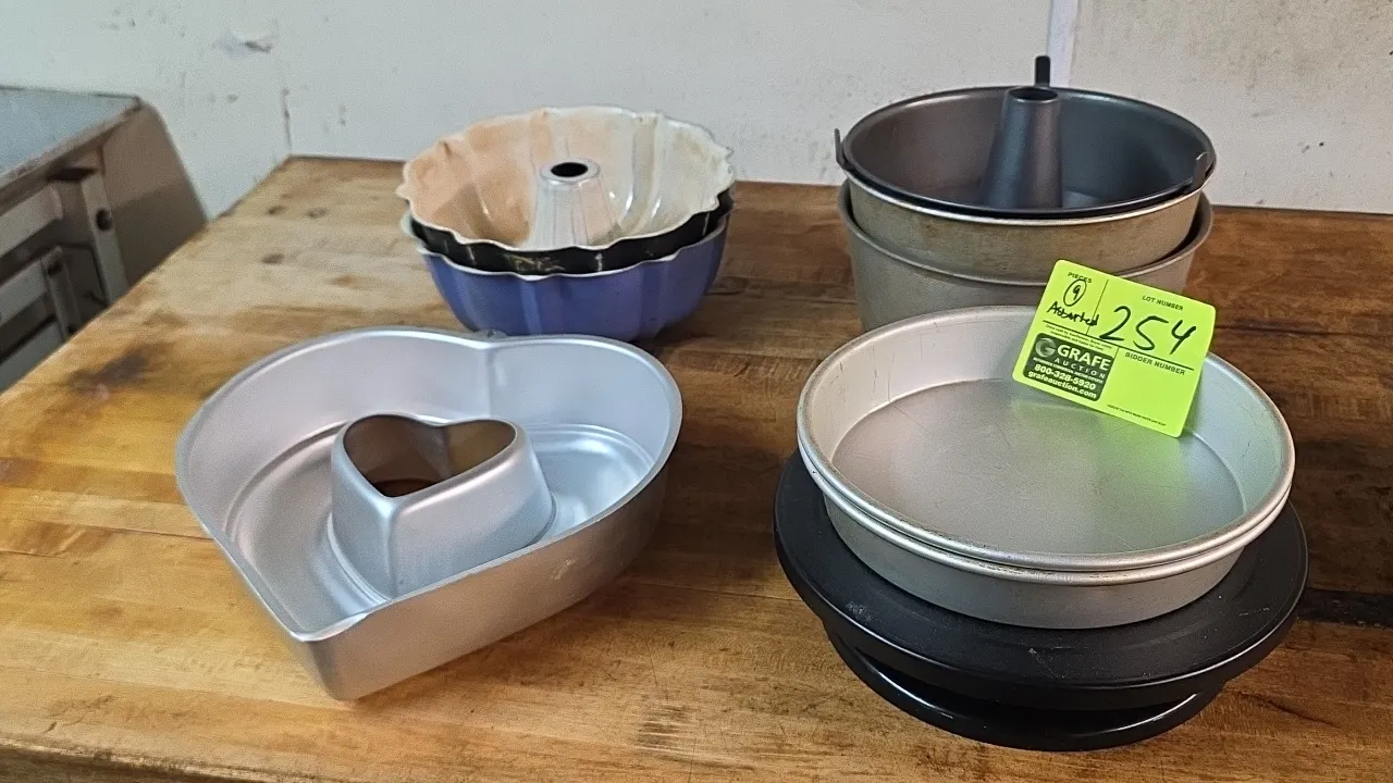 Assorted aluminum and coated baking pans. Includes (9) pieces total: fluted bundt pans, a heart-shaped tube pan, angel food cake tube pans, and round