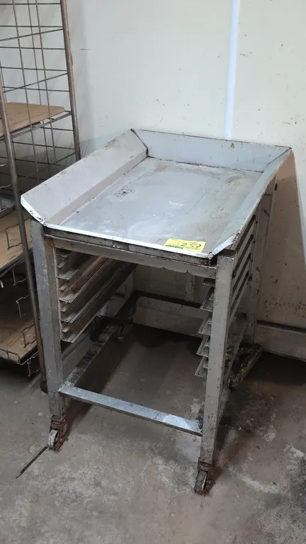 Aluminum dump cart. Features a 3-sided flanged top tray and 5-tier pan/tray slides. Mounted on swivel casters.