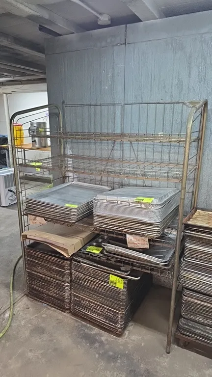 Metal 4-tier shelving rack. Features tubular metal frame with wire back grid and 4 tiers of adjustable wire shelves. Contents not included.