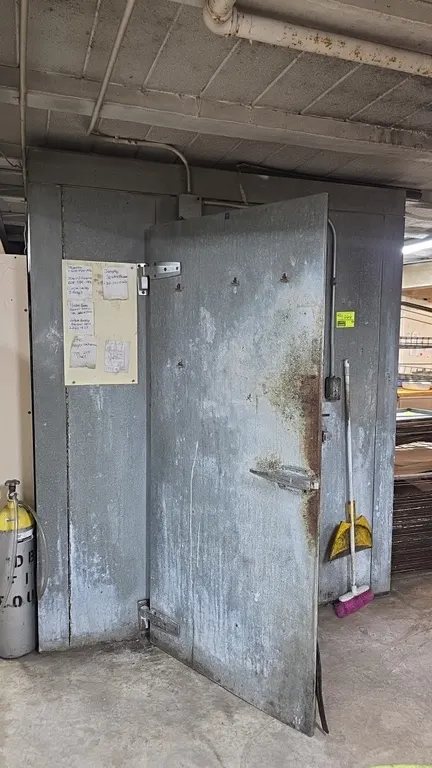 Walk-in insulated cooler with Heatcraft 2-fan evaporator. Features a 34" x 74" entryway door with heavy-duty latch and ceiling-mounted 2-fan evaporato