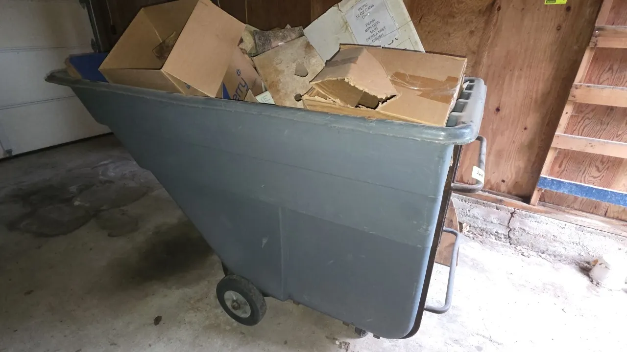 Rubbermaid portable poly dumpster. Features a molded polyethylene body with a tubular steel frame and integrated push handle. 7'L. Mounted on wheels a