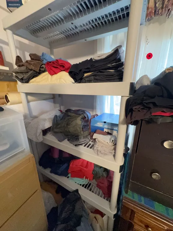 Plastic Shelving Unit With Assorted Clothing and Contents Included