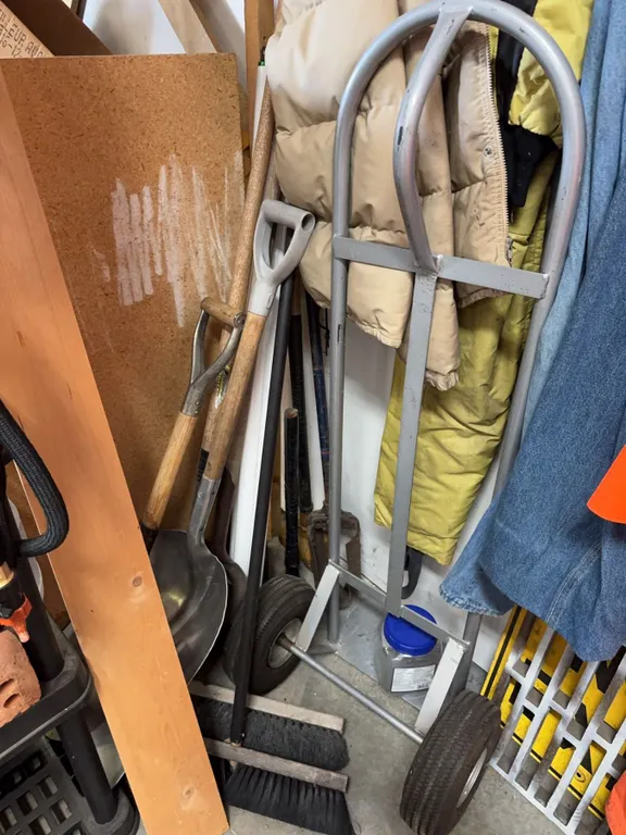 Metal Dolly and Assorted Hand Tools Including Shovel, Rake, Brooms, and Garden Tools