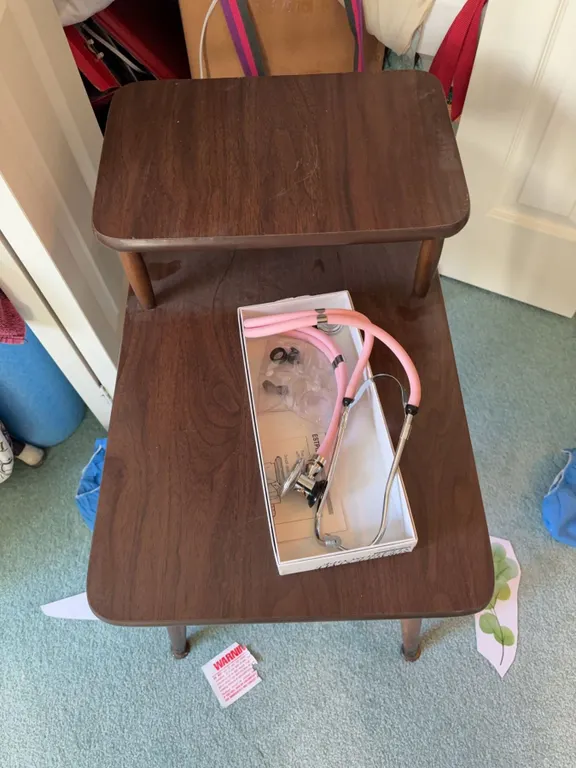 Closet Contents Including Table, Pink Stethoscope, Water Bottle, Hangers, and Bags