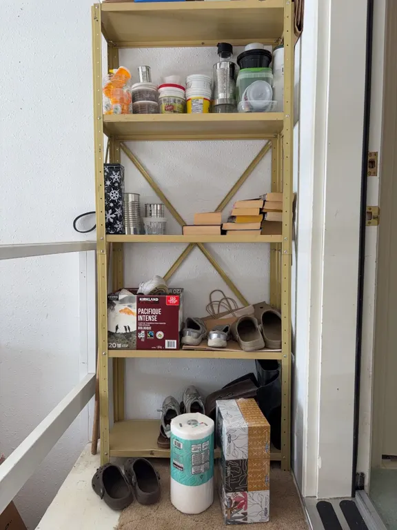 Metal Storage Rack with Contents Including Jars, Cups, Shoes, Books, Paper Towels, Boxes