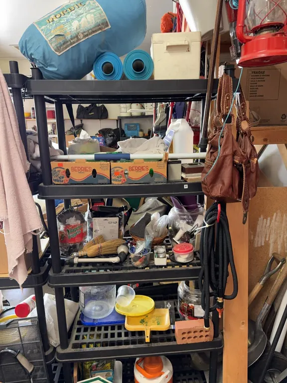 Household and Garage Items Including Sleeping Bag, Cooler, and Storage Bins
