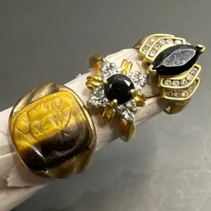 Three Gold-Tone Rings with Black and Amber-Style Stones