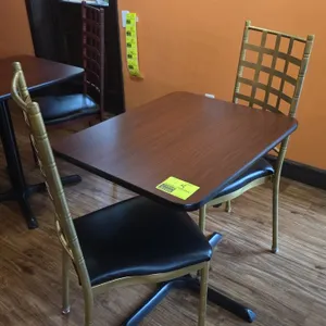 Restaurant table and chair set. Includes a 24" x 30" woodgrain laminate tabletop mounted on a black metal pedestal X-base and (2) gold-tone metal fram