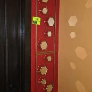 Metal frame hexagon mirror wall decor. Features (2) gold-tone metal framed panels with geometric hexagonal mirror accents. 12" x 32". Wall-mounted.