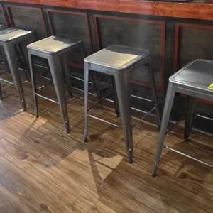 Metal bar height stools. Features backless design, square metal seats, integrated footrests, and tapered legs with floor glides. Gunmetal finish. 15" 