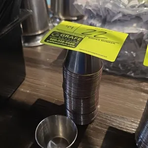 Stainless steel condiment holders. Features a stackable design with flared rims suitable for sauces, dips, and dressings.
