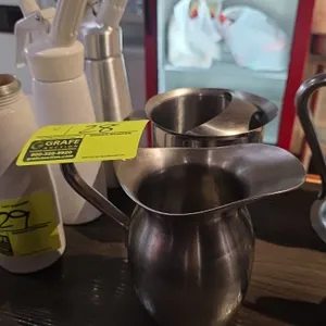 Stainless steel pitchers. Includes (1) Lalance & Grosjean Crusader Ware creamer pitcher and (1) water pitcher with ice guard. Features stainless steel