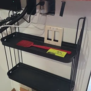 Metal 2-tier shelf. Features black metal wire frame construction with two solid shelf trays. 20" x 20". Wall-mount design. Contents not included.
