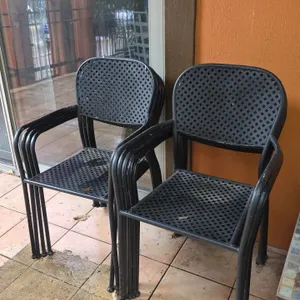Metal outdoor armchairs. Features diamond mesh pattern seats and backs, integrated armrests, and tubular metal frames. Stackable design.