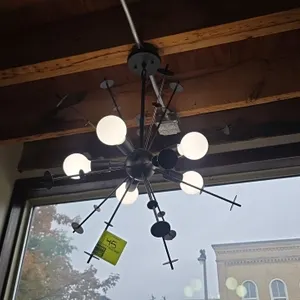 Metal chandelier. Features modern sputnik-style multi-directional design with radiating rods, disc accents, and ceiling mounting canopy. 20" x 32". In
