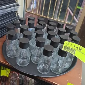 Glass soy sauce dispensers. Features clear glass construction with black poly pourer lids. Includes 16" poly serving tray.