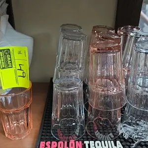 Paneled glass water tumblers. Features faceted exterior design and stackable rim. Includes a mix of clear and blush-tinted glasses. Bar mat not includ