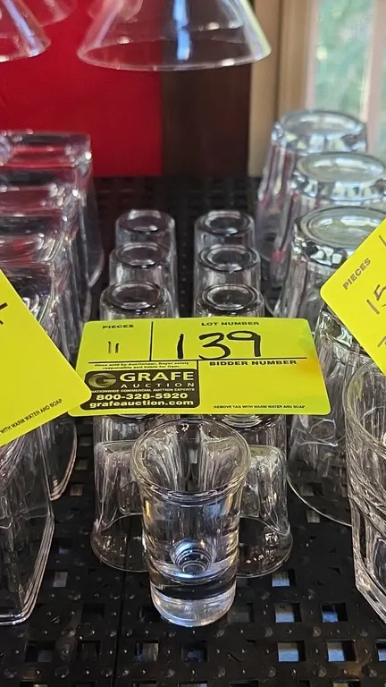 Clear glass shot glasses. Features a fluted design with a thick solid base.