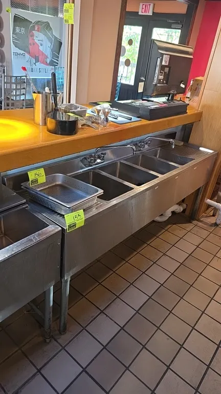 Stainless steel 4-compartment underbar sink. Features left and right embossed drainboards, (2) backsplash-mounted swivel faucets, overflow standpipe t