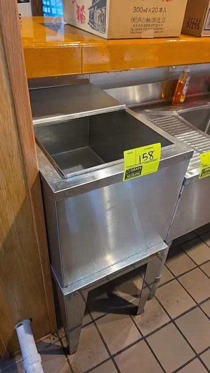 Stainless steel undercounter ice bin. Features a sliding stainless steel lid and bottom drain. 15" x 24". Mounted on stainless steel legs.