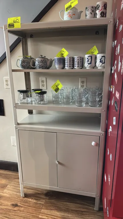 Metal 4-tier storage cabinet. Features open upper shelving and lower two-door cabinet with interior storage shelf. Beige powder-coated finish. 31" x 1