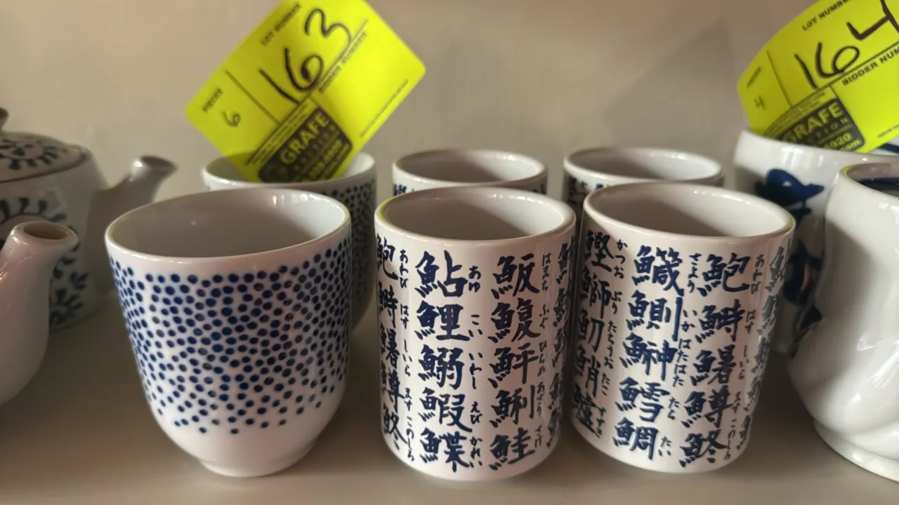 Decorative ceramic tea cups. Includes (4) cups featuring blue Japanese fish kanji calligraphy and (2) cups featuring blue dot patterns. White glazed c