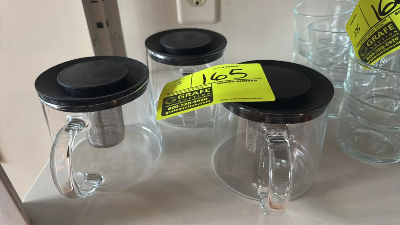 Glass tea diffuser kettles. Features clear glass carafes with integrated glass handles, removable stainless steel mesh infuser baskets, and black lids