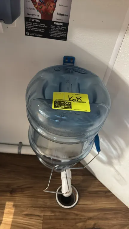 San Jamar poly ice bucket. Features clear blue plastic construction, wire bail handle with comfort grip, molded bottom pour handle, and wall hanging b