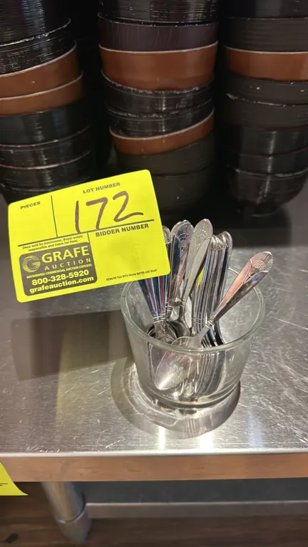 Stainless steel wasabi spoons with clear glass container. Spoons feature decorative fan-detailed handles. Dimensions: 4 1/2"L spoons.