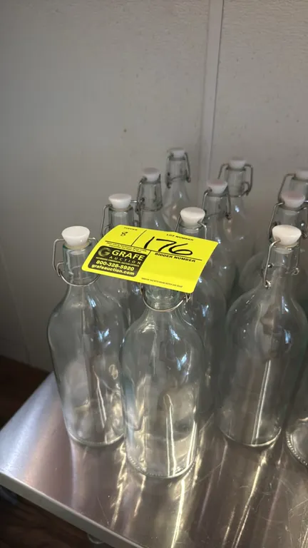 Glass water carafes. Features clear glass construction with swing-top wire bail closures and stoppers. 12"H.