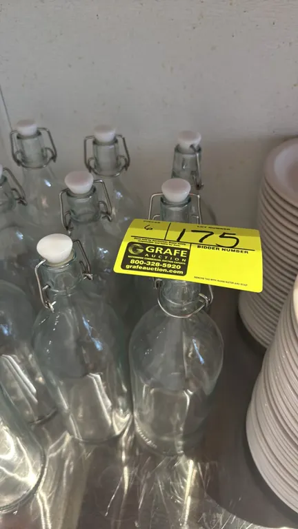 Glass water carafes. Features clear glass construction and swing-top wire bail stoppers. 12"H.