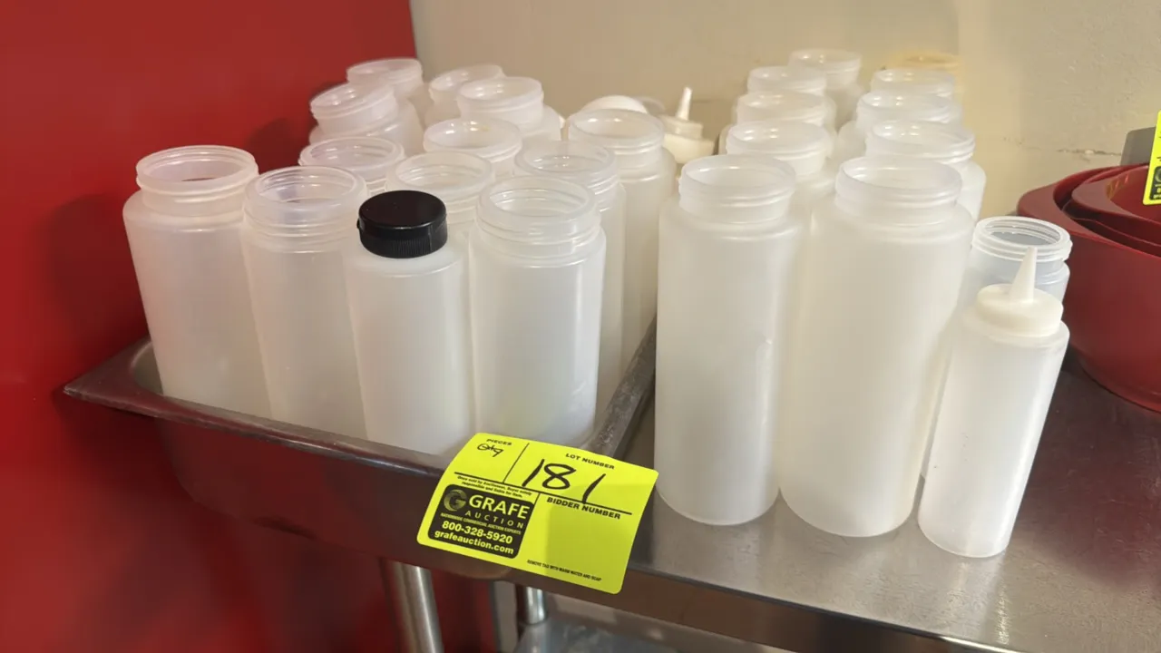 Assorted poly condiment squeeze bottles with stainless steel insert pan. Features bulk lot of translucent squeeze dispensers in various sizes, dispens