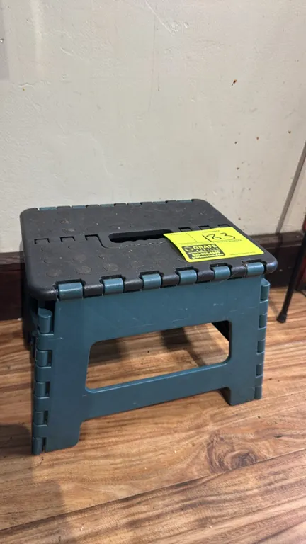 Poly collapsible step stool. Features a folding design with integrated carry handle and textured non-slip stepping surface.