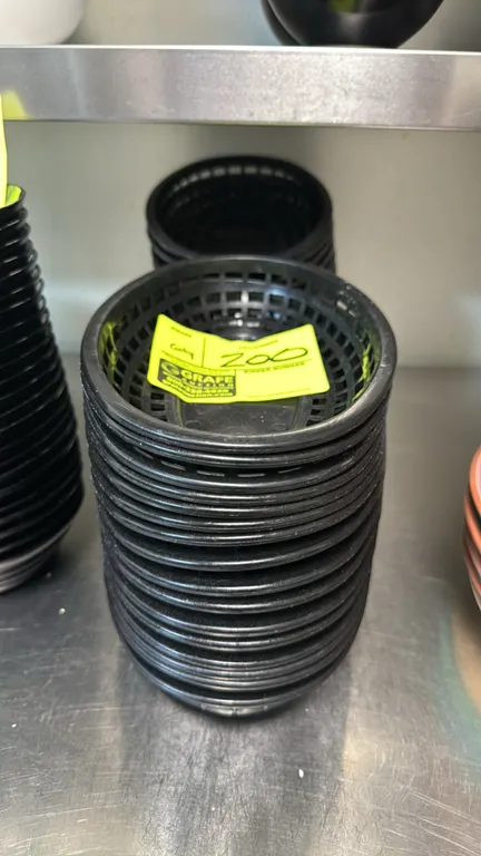 Bulk lot of 9" plastic serving baskets. Features black polypropylene construction, oval shape, and lattice sides.