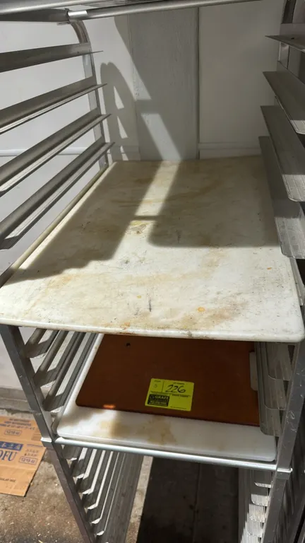 Assorted cutting boards. Includes white polyethylene and composite boards in various sizes and shapes. Note: Sheet pan rack not included.