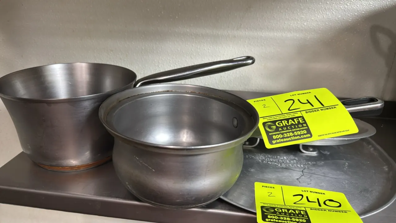 Stainless steel sauce pans. Includes a KitchenAid saucepan with a riveted handle and copper-accented base, and a stainless steel saucepan. 6 1/2" diam